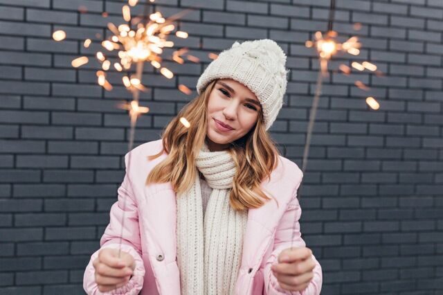 fascinating-white-woman-cute-winter-attire-posing-with-sparklers-outdoor-shot-lovable-girl-standing-urban-street-with-bengal-lights_197531-8389